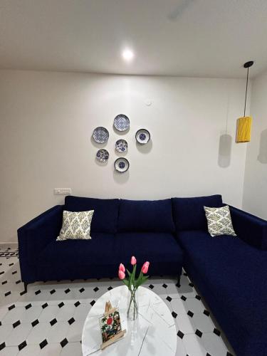 a living room with a blue couch and a table at Heritage The Bosque By StayUkiyo in Mapusa