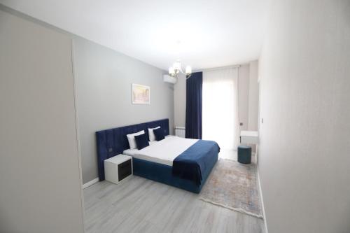 a bedroom with a bed with a blue head board at Passage Hotel in Baku