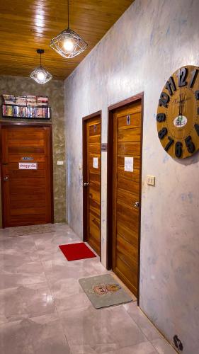 a room with two wooden doors and a red rug at Baan Bonkao Resort Sattahip in Ban Khlot
