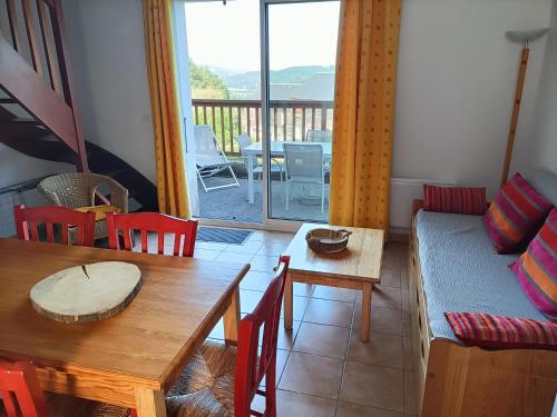 un salon avec une table et un canapé dans l'établissement Gîte du Gua des Brasses au bord du lac de la Raviège, à La Salvetat-sur-Agout