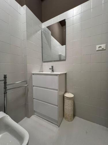 a white bathroom with a sink and a mirror at Charme on the Lake - Dimora Spighetta in San Zeno di Montagna