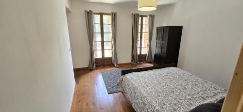 a bedroom with a bed and two windows at Pyrenean Pursuits in Biert