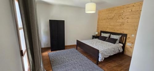 a bedroom with two beds and a wooden wall at Pyrenean Pursuits in Biert