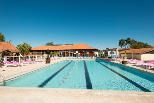 une grande piscine avec des chaises et un bâtiment dans l'établissement emplacement 490, à Gastes