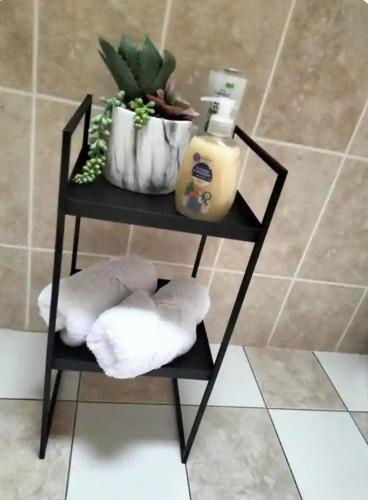 a black shelf with towels and a bottle of soap at Lomonagh Lodge Portmagee in Lateeve