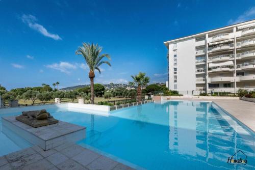 une grande piscine devant un immeuble dans l'établissement Azur Élégance, piscine & plages, à Antibes