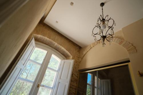a chandelier in a room with a window and a mirror at Leano Agriresort in Piazza Armerina