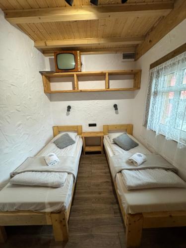 a room with two beds and a tv in it at MOTOMYCZKI-motel in Myczkowce