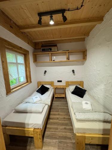 a room with two beds and a desk in it at MOTOMYCZKI-motel in Myczkowce