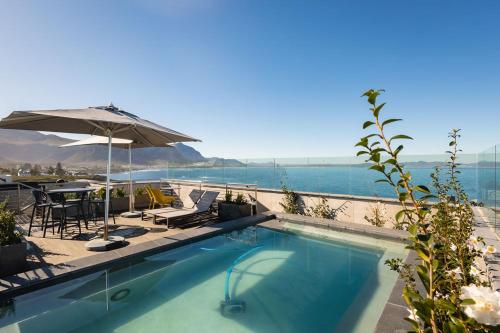 a swimming pool with a view of the water at Ocean-View Studio Apartment, Hermanus Waterfront - Apt 8 in Hermanus