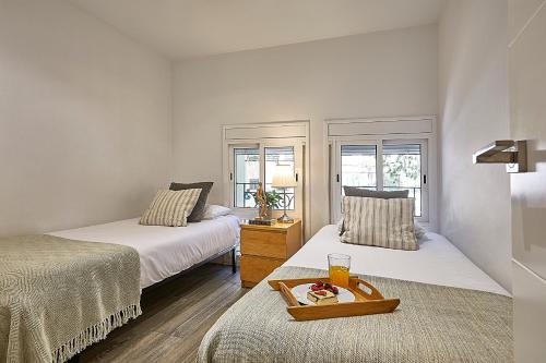 a room with two beds and a tray of food on a table at BBarcelona Sant Pau Flat in Barcelona