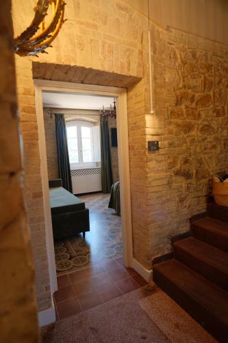 a room with a stone wall and a stair case at Leano Agriresort in Piazza Armerina