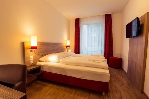a hotel room with a bed and a window at guestified MILO NOEL Hotel in Bonn
