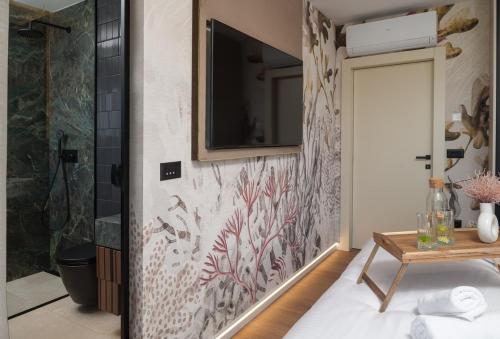 ein Bad mit Dusche und ein TV an der Wand in der Unterkunft New! Luxury Villa Cvita-design award winner 2025 in Seline