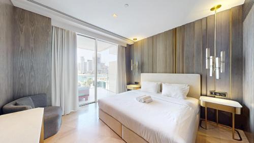 a bedroom with a large white bed and a window at Vacationer Holiday Homes I Opulent 2 Bedroom I Sea View I Beach Access l FIVE Palm in Dubai
