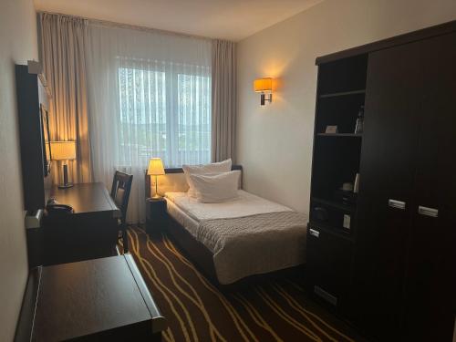 a hotel room with a bed and a window at Hotel Business Faltom Gdynia in Rumia