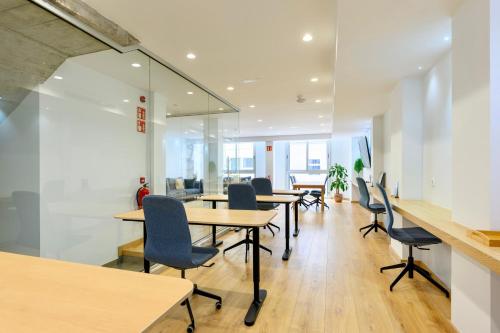an office with tables and chairs and glass walls at Hotel Emeté & Coworking by Airnest in Las Palmas de Gran Canaria