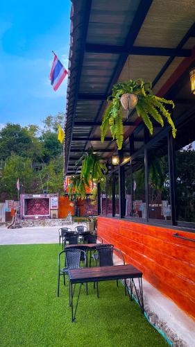 a group of tables and chairs in front of a building at Baan Bonkao Resort Sattahip in Ban Khlot