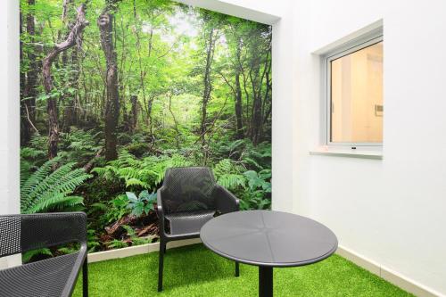 a room with a table and chairs and a mural of a forest at Hotel Emeté & Coworking by Airnest in Las Palmas de Gran Canaria