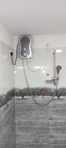 a shower with a hose attached to a wall at Sigiriya Mirror wall Guest house in Sigiriya