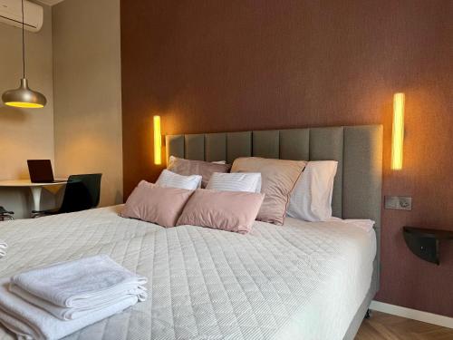 a bedroom with a large bed with pink and white pillows at ROOSEVELTA RESIDENCE Apartments - przy OFF Piotrkowska in Łódź