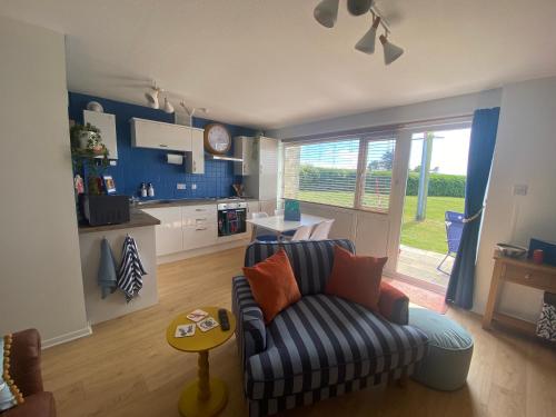 a living room with a couch and a kitchen at Seagulls Rest in Isle of Wight