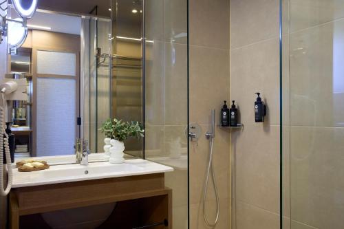 a bathroom with a shower and a sink and a shower at Mirabello Bay Luxury Resort in Agios Nikolaos