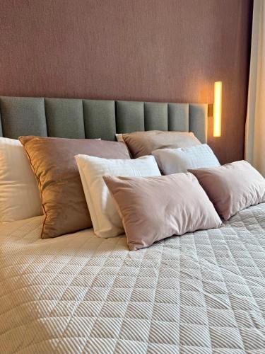a large bed with white pillows on it at ROOSEVELTA RESIDENCE Apartments - przy OFF Piotrkowska in Łódź