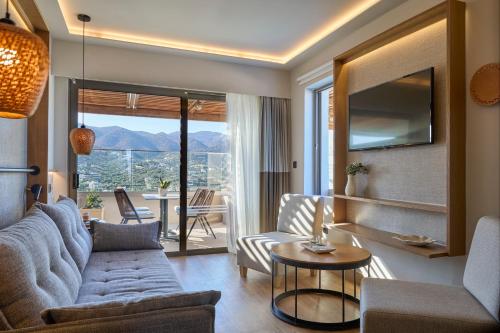 a living room with a couch and a table at Mirabello Bay Luxury Resort in Agios Nikolaos