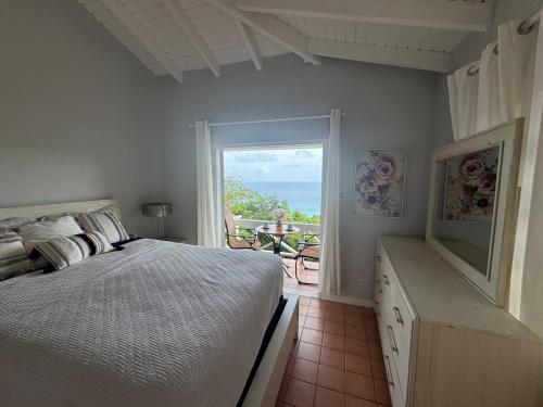 a bedroom with a bed and a view of the ocean at BluEdge Villa VIP Resort Access in Tortola Island