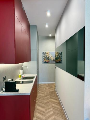 a kitchen with red and white cabinets and a sink at ROOSEVELTA RESIDENCE Apartments - przy OFF Piotrkowska in Łódź
