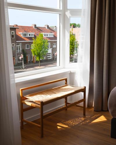 a bench sitting in front of a window at Limehome Utrecht Balijelaan in Utrecht