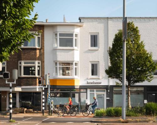 two people riding bikes in front of a building at Limehome Utrecht Balijelaan in Utrecht