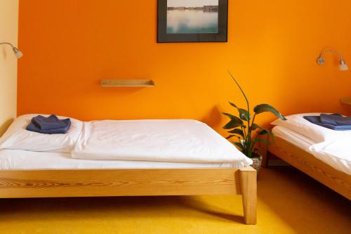 a bedroom with two beds and an orange wall at Schanzenstern Altona GmbH in Hamburg