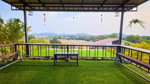 a picnic table on a deck with a view of a field at Baan Bonkao Resort Sattahip in Ban Khlot