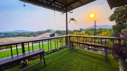 a balcony with benches and a view of a field at Baan Bonkao Resort Sattahip in Ban Khlot