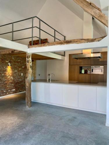 a kitchen with white cabinets and a loft bed at Hoeve DeKleinheide 1 in Dessel