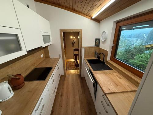 a kitchen with white cabinets and a window and a sink at Ferienhaus Kötschach 356 in Kötschach