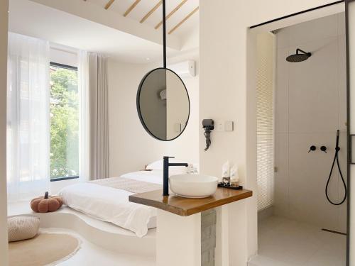 - une chambre blanche avec un lavabo et un miroir dans l'établissement 吾桐小院, à Zhangjiajie