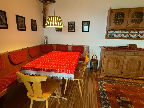 a dining room with a red table and chairs at Ferienhaus Kötschach 356 in Kötschach