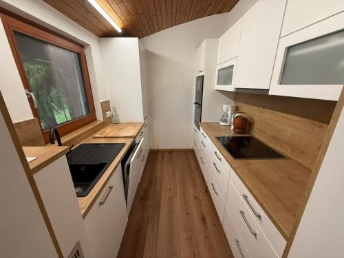 a small kitchen with white cabinets and a window at Ferienhaus Kötschach 356 in Kötschach