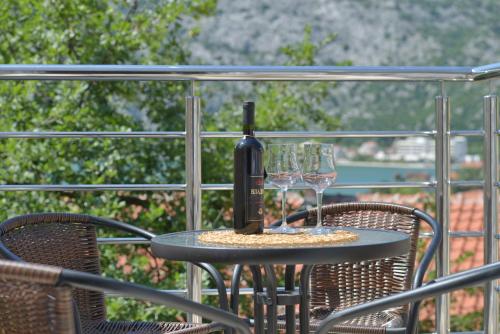 a bottle of wine sitting on a table with two glasses at Apartments Risan in Risan