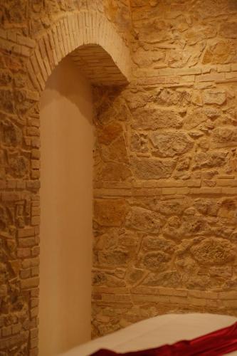 a stone wall with an arch in a bedroom at Leano Agriresort in Piazza Armerina