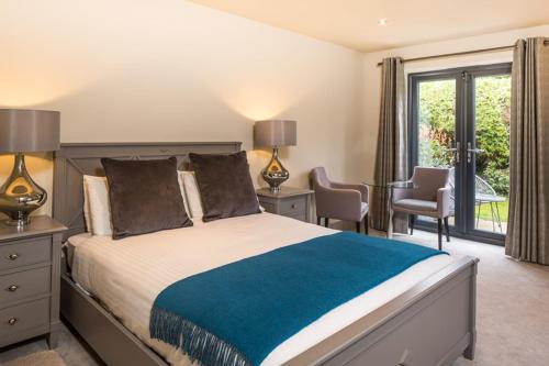 a bedroom with a large bed with two lamps and a window at The Chequers Inn in Beaconsfield