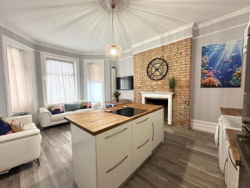 a living room with a kitchen and a fireplace at The Bournemouth Haven - Brought to you by Coastline Retreats - Grand 2 bedroom luxury apartment - 3 mins walk to beach - Superfast Wifi - Sleeps 6 in Bournemouth