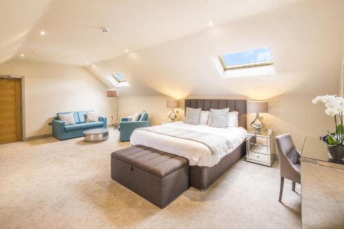 a bedroom with a bed and a couch and chairs at The Chequers Inn in Beaconsfield