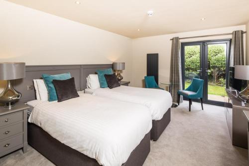 a large bedroom with two beds and a television at The Chequers Inn in Beaconsfield