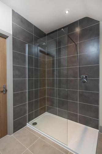 a shower with a glass door in a bathroom at The Chequers Inn in Beaconsfield
