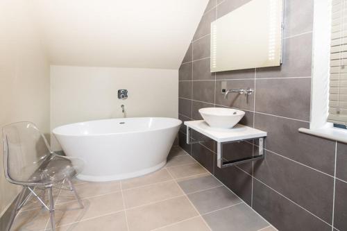 a bathroom with a white tub and a sink at The Chequers Inn in Beaconsfield