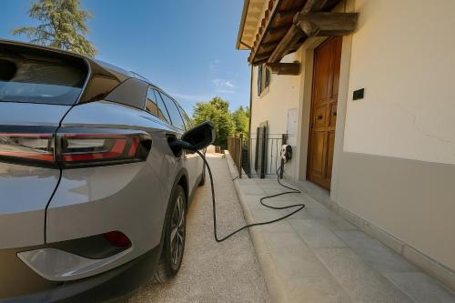 a car parked next to a house with a charging cord at Villa La Gioconda in Arezzo